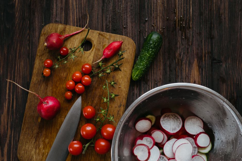 A vibrant arrangement of fresh vegetables on a wooden chopping board, ideal for healthy cooking concepts.